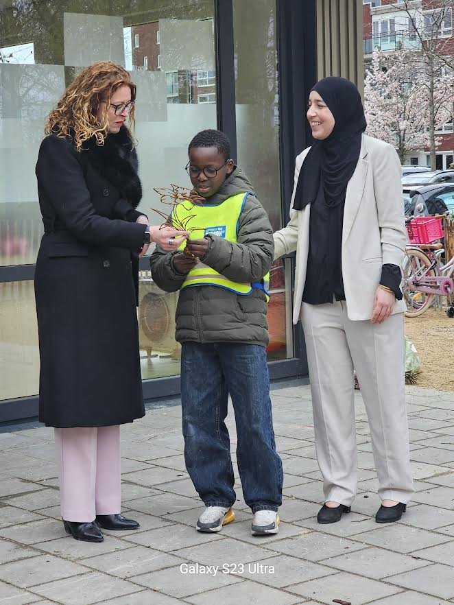 Wethouder Denise Mulder en een leering en docent van IKC de Reiziger ruimen zwerfafval op.